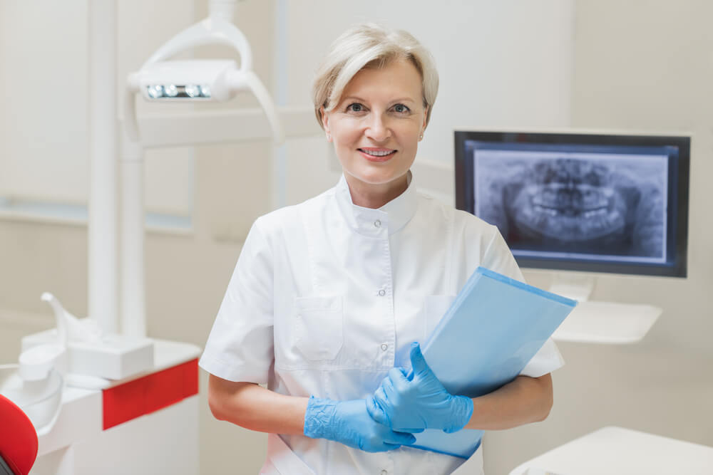 dentista segurando papel lei sobre aparelho ortodôntico