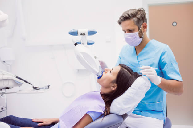 odontologia do esporte dentista realizando procedimento na paciente 
