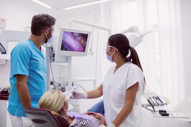 decoração de consultorio odontologico dentista e auxiliar analisando paciente