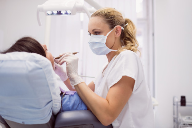 excelencia no dentimento dentista realizando procedimento na paciente