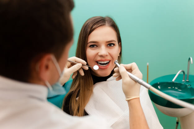 patologia oral mulher sorrindo em um atendimento odontologico
