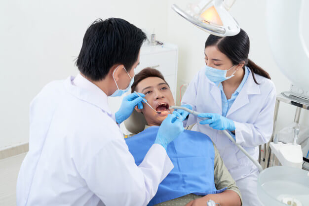 comercial de odontologia dois dentistas atendendo paciente juntos