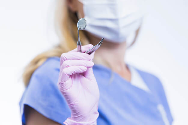 curiosidades sobre odontologia dentista mulher segurando equipamento odontologico