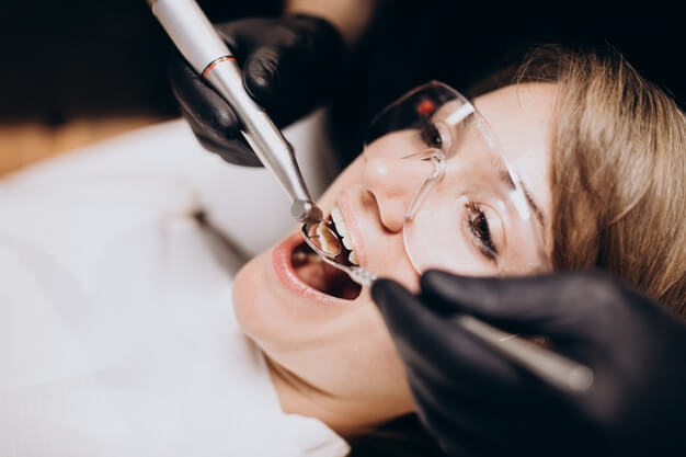 curiosidades sobre odontologia mulher com oculos de proteção no dentista