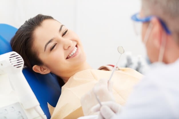 curiosidades sobre odontologia paciente mulher sorrindo enquanto faz procedimento odontologico