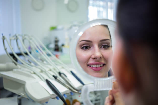 cirurgia guiada mulher olhando sorriso no espelho