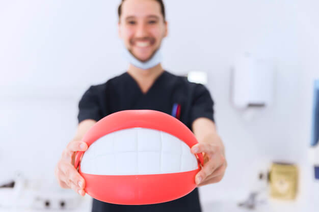 faculdade de odontologia dentista segurando boca grande