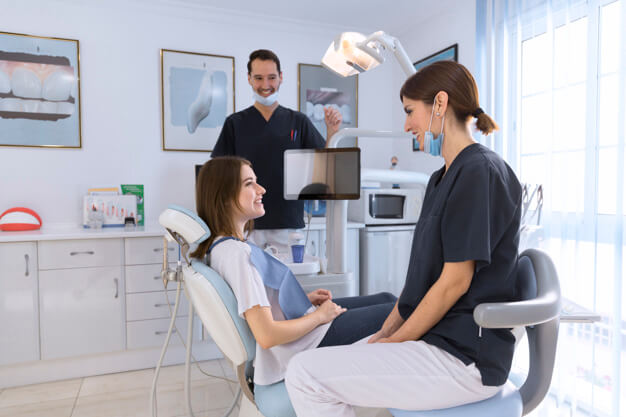 auxiliar de saúde bucal e dentista em atendimento