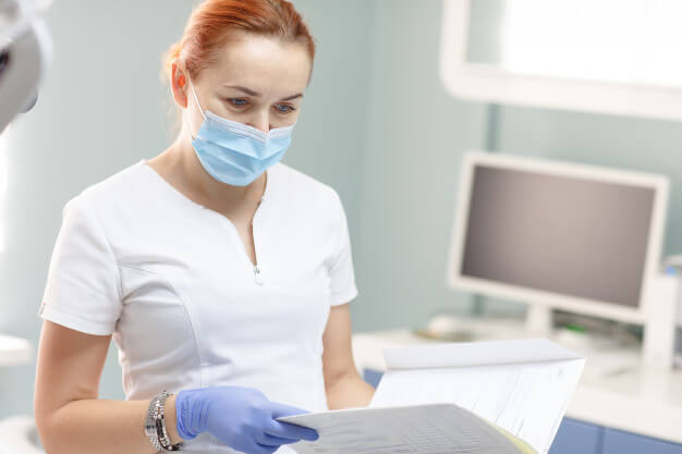 dentista segurando ficha de anamnese